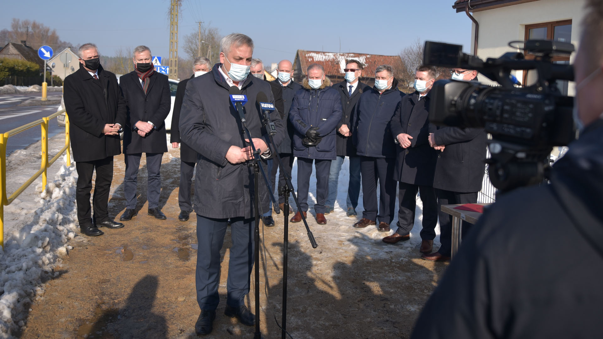 Grupa ludzi wypowiada się przed kamerami